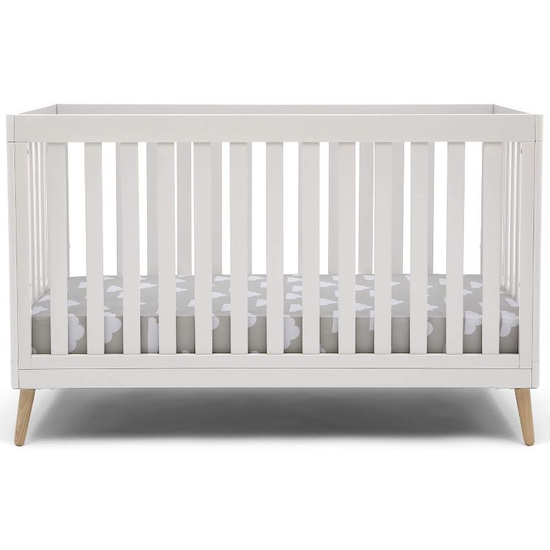 Photo 1 of Delta Children Essex 4-in-1 Convertible Baby Crib, Bianca White with Natural Legs + Simmons Kids Quiet Nights Dual Sided Crib and Toddler Mattress (Bundle)