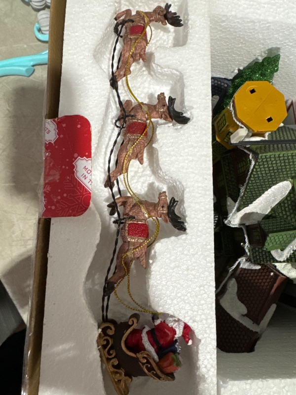 Photo 1 of * DAMAGED READ NOTES*Christmas Village Centerpiece Decor, Santa Riding in Sleigh, with Christmas Tree and Village Buildings, Featuring LED Lights, Christmas Music, and Animation Power Adapter Included
