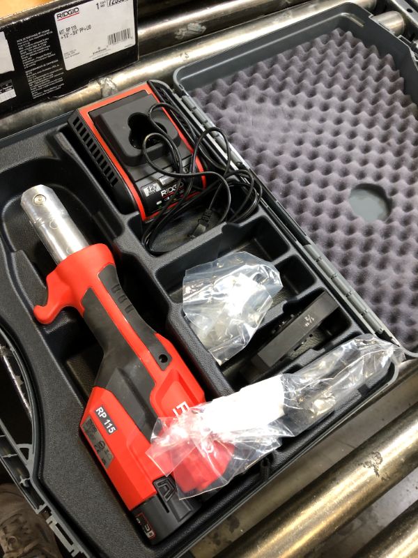 Photo 2 of RIDGID 72553 Model RP 115 Mini Press Tool and Battery Kit with 1/2" to 3/4" ProPress Press Tool Jaws, 2V Li/Ion Battery, 12V Charger, and Carrying Case , Red
