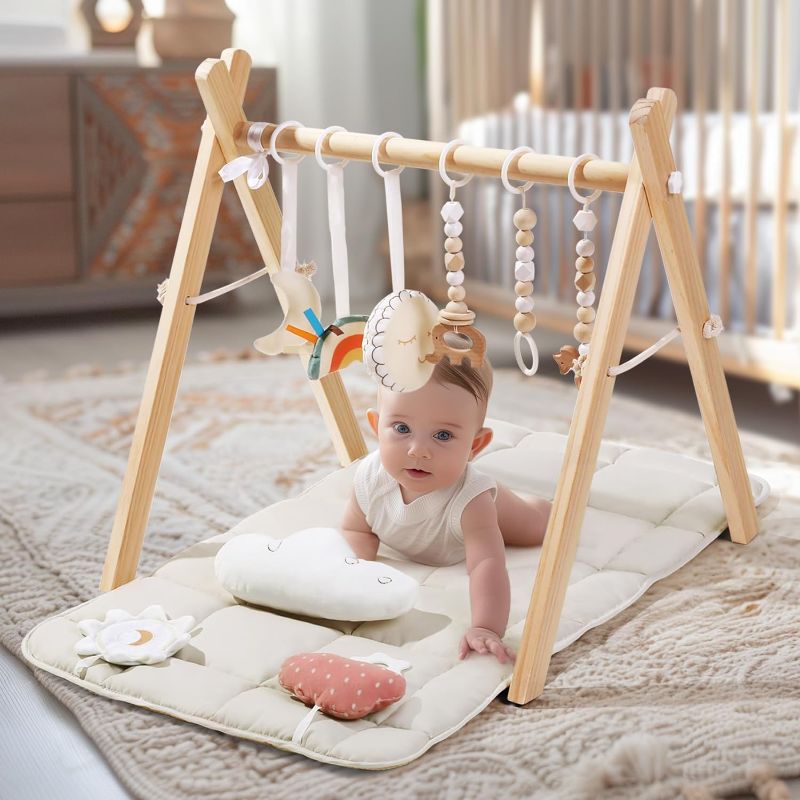 Photo 1 of Foldable Baby Play Gym with Mat, Wooden Play Gym with 9 Sensory Toys, Frame Activity Center, Natural Pine Wood, Montessori Toys, Easy to Assemble & Clean, Newborn Gift, Natural Color
