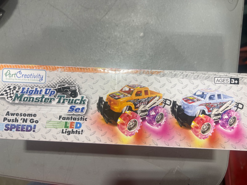 Photo 1 of ArtCreativity Orange and White Light Up Monster Truck Set for Boys and Girls, Set includes 2, 6 Inch Monster Trucks with Beautiful Flashing LED Tires, Push n Go Toy Cars, Best Gift for Kids Ages 3+

