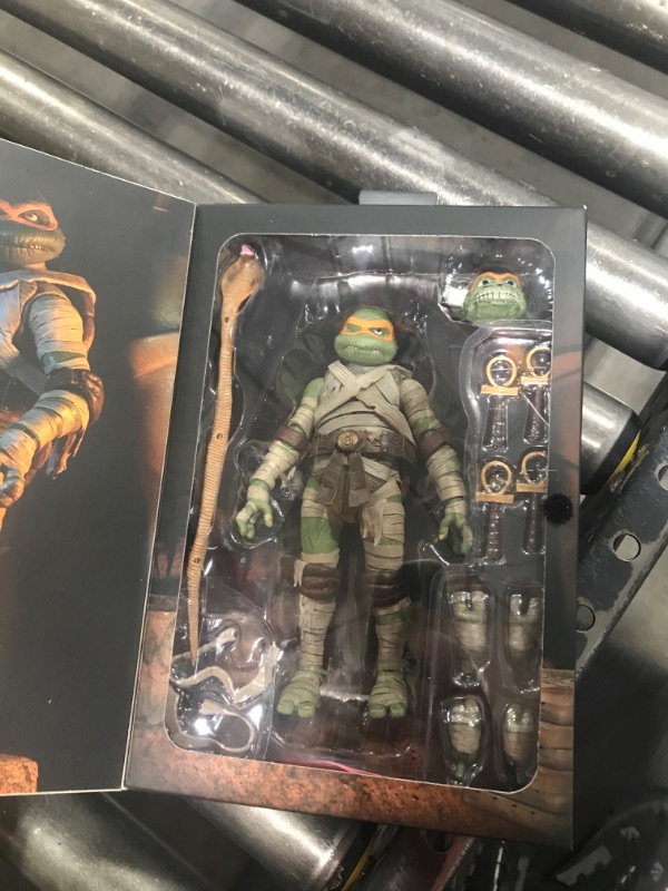 Photo 2 of  NECA Universal Monsters X Teenage Mutant Ninja Turtle 7-Inch Scale Ultimate Michelangelo Mummy Action Figure with Interchangeable Heads and Accessories 