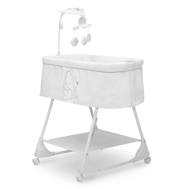 Photo 1 of Delta Children – Disney Winnie The Pooh Bassinet with Stationary Mobile Arm, Vibration, Nightlight and Music, White/Grey