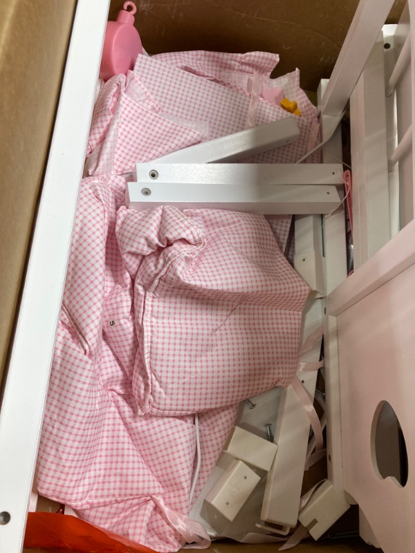 Photo 4 of Badger Basket Toy Doll Bed - Wood Doll Crib Bassinet with Bedding and Storage, Fits 22 Inch Dolls, White/Pink Gingham