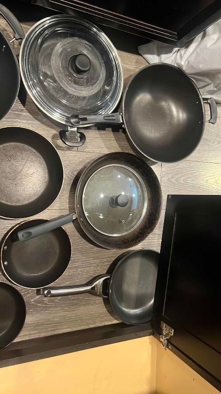 Photo 1 of CONTENTS OF CABINET PANS, SKILLETS, LARGE SERVING PLATES, AND A  CALPHALON PAN