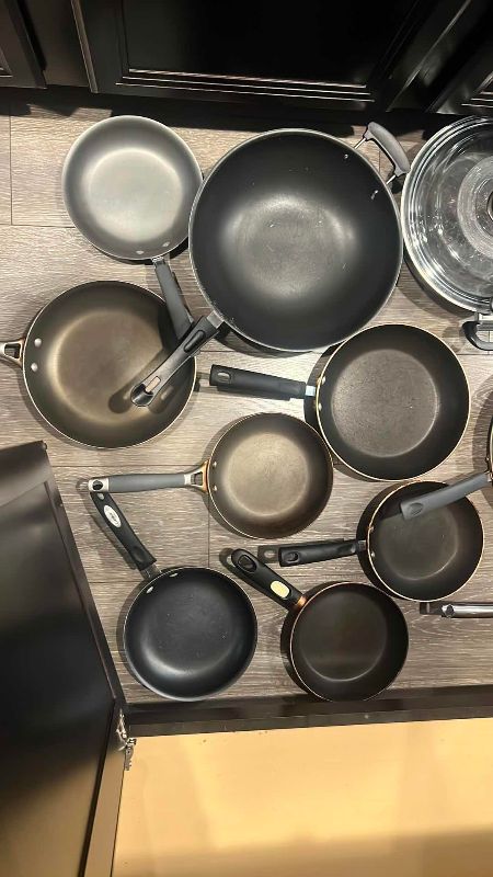 Photo 1 of CONTENTS OF CABINET PANS, SKILLETS, LARGE SERVING PLATES, AND A  CALPHALON PAN