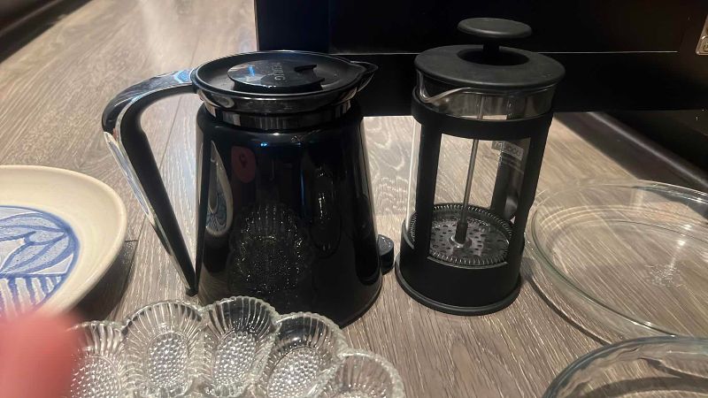 Photo 1 of CONTENTS OF CABINET NICE PLATES, TORTILLA HOLDER, CAKE PANS, COFFEE PRESS, ELECTRIC WATER HEATER