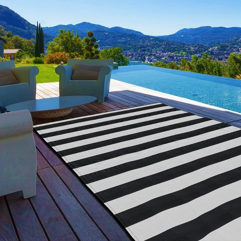 Photo 1 of Pcinfuns Plastic Straw Rug,6'x9' Outdoor Waterproof Patio Rugs Foldable Reversible Camping Mat for Rv, Deck, Porch, Picnic, Beach, Balcony,Black & White
