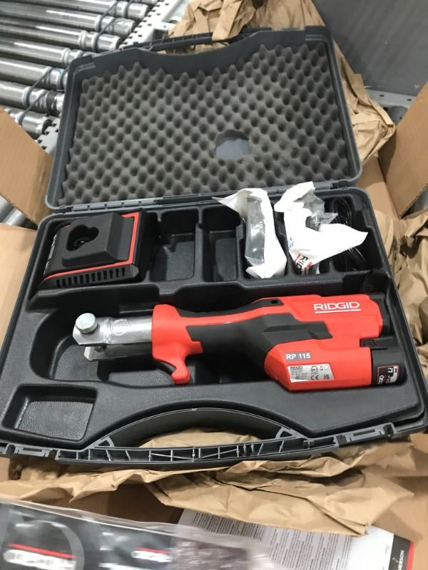 Photo 1 of RIDGID 72553 Model RP 115 Mini Press Tool and Battery Kit with 1/2" to 3/4" ProPress Press Tool Jaws, 2V Li/Ion Battery, 12V Charger, and Carrying Case , Red