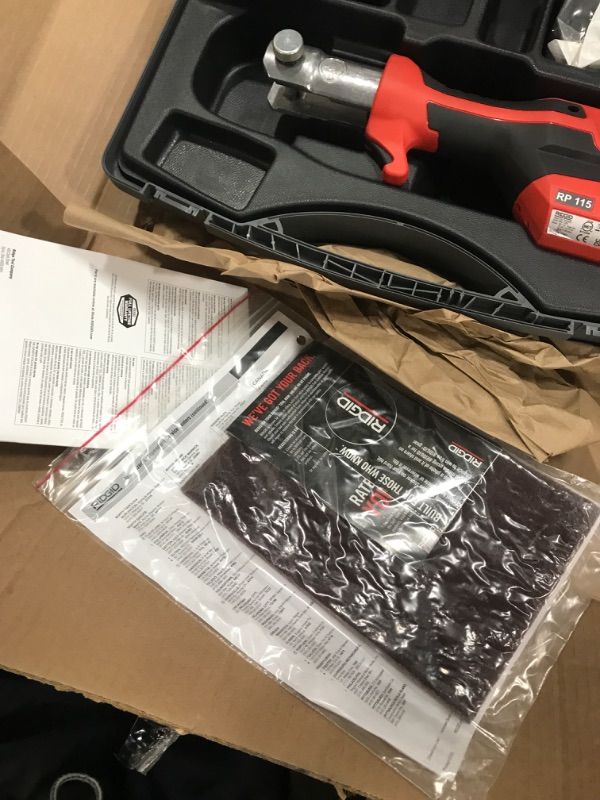Photo 1 of RIDGID 72553 Model RP 115 Mini Press Tool and Battery Kit with 1/2" to 3/4" ProPress Press Tool Jaws, 2V Li/Ion Battery, 12V Charger, and Carrying Case , Red
