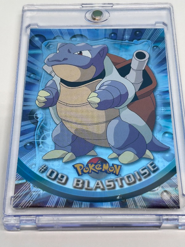 View 1 of 166042…Holofoil Blastoise Pokemon card in hard plastic case