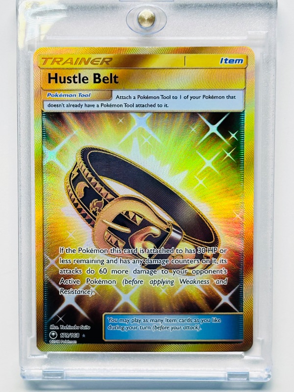 Photo 1 of 025257…Trainer Hustle Belt holo Pokémon card in hard plastic case