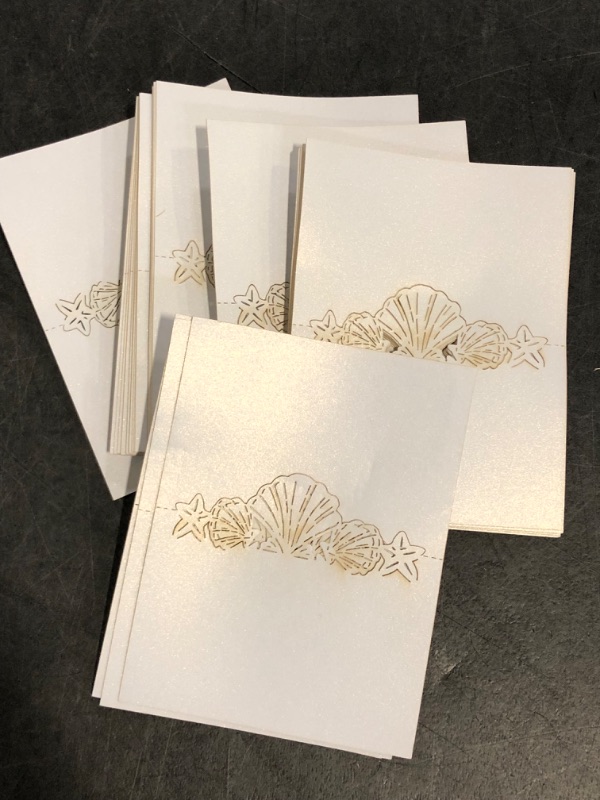 Photo 1 of Set of 50 Nautical Place Cards for Table Setting, Seashell and Starfish Cutout Name Cards for Beach Wedding Party Shower, White
