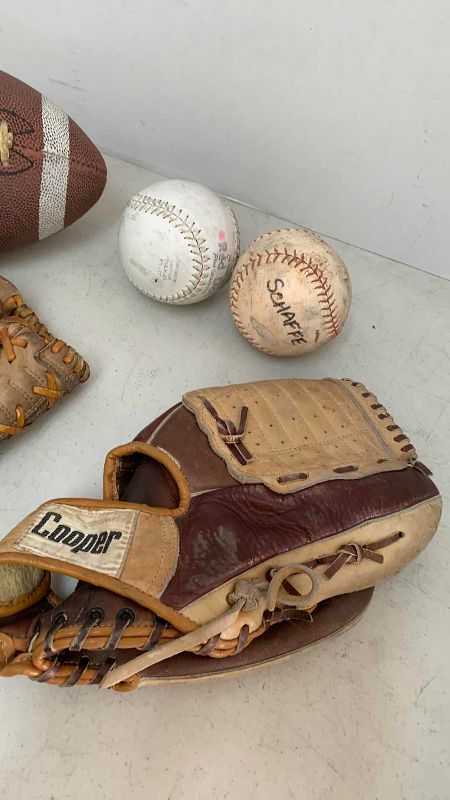 Photo 1 of 2-BASEBALL GLOVES, 2-SOFTBALLS, AND A JR. FOOTBALL