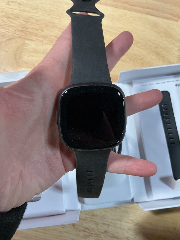 Photo 1 of **NOT INA BOX PHOTO FOR REFERENCE FOR PARTSA ONLY/ NON-FUNCTIONAL*** Fitbit Versa 4 Smartwatch (Bundle) – GPS Fitness Tracker with Fast Charger & Cleaning Cloth, 40+ Exercise Modes, Heart Rate, Sleep, Step, & Workout Tracking for Android & iPhone, Black/G