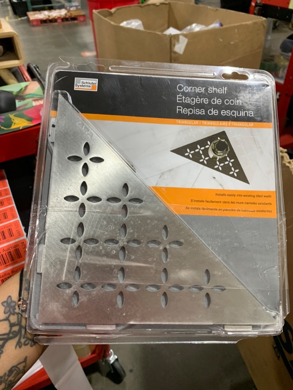 Photo 1 of Schluter Triangular Corner Shelf for Tiled Walls - Floral Design, Stainless Steel Material, Brushed Stainless Steel Finish, 3/32” Thick Anchoring Tabs - SES1D5EB