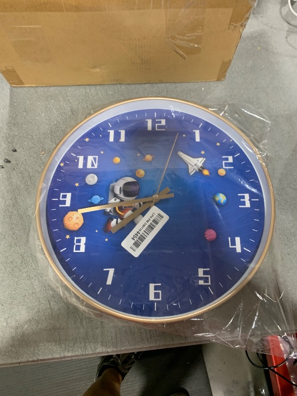 Photo 1 of QINFIEY 12 Inch Silent Movement Kids Wall Clock, Non Ticking Children Round Wall Clock Battery Operated Space Travel Style Decor Children Clock for Home School Boys Bedroom Living Room (Blue-2)