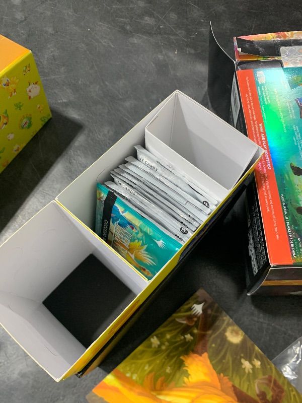 Photo 1 of opened----------------------------Magic: The Gathering - Final Fantasy Chocobo Bundle (1 Chocobo Booster, 10 Play Boosters, 1 Alt-Art Promo Card, 1 Scene Card, 32 Basic Lands, 1 Click Wheel, and More)