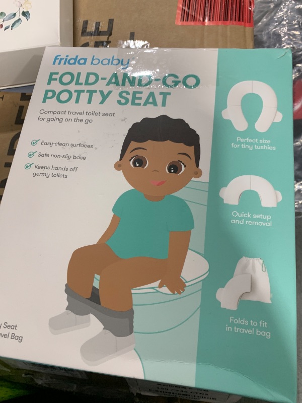 Photo 1 of Frida Baby Fold-and-Go Portable Potty Seat for Toilet, Foldable Travel Potty Seat for Toddler, Fits Round & Oval Toilets, Non-Slip Base, Handles, Includes Free Travel Bag
