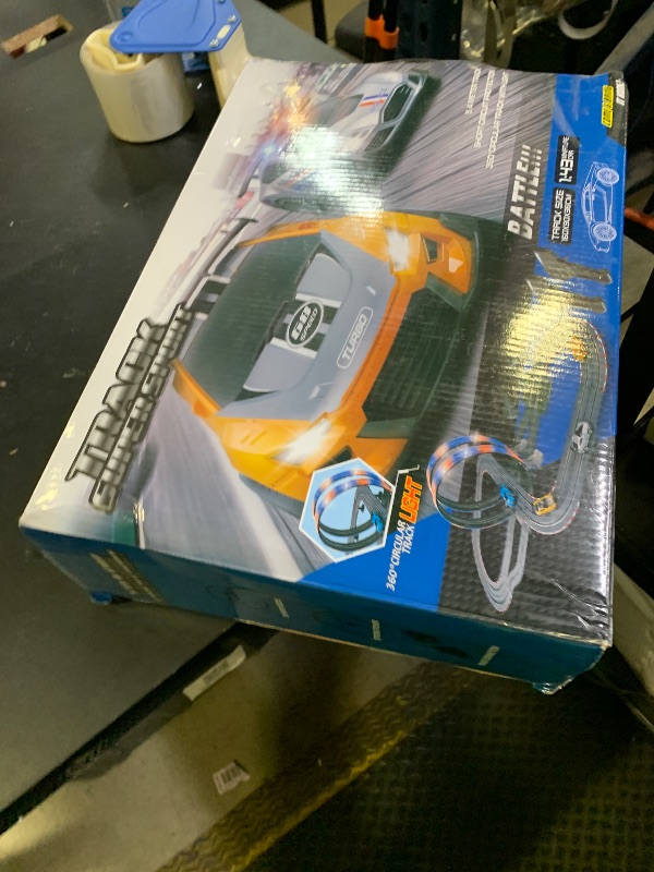 Photo 1 of Slot Car Race Track Set, 19ft Electric Track with LED Lights and 4 Slot Cars, 2 Hand Controllers and Racing Game Lap Counters, Set Features Loop, Turns, and Crossover for Boys Age 6-12