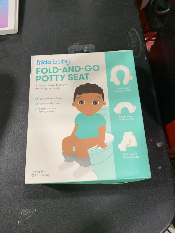 Photo 1 of Frida Baby Fold-and-Go Portable Potty Seat for Toilet, Foldable Travel Potty Seat for Toddler, Fits Round & Oval Toilets, Non-Slip Base, Handles, Includes Free Travel Bag