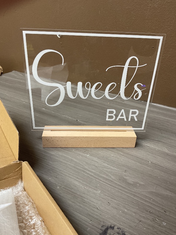 Photo 1 of Hoolerry LED Acrylic Bar Table Sign 8" x 10" Neon Acrylic Sign, Snack Candy Bar Sign with Stand Clear Acrylic Sign with White Text for Dessert Flower Bar Decor(Sweets Bar Sign)