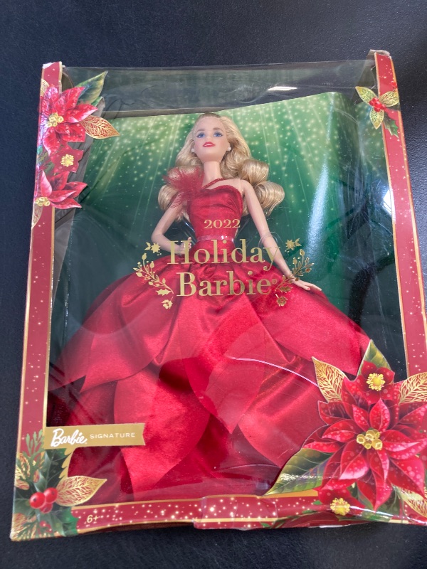 Photo 1 of Barbie Signature 2022 Holiday Doll, Blonde Wavy Hair Wearing Red Poinsettia-Inspired Gown, Collectible with Doll Stand & Certificate of Authenticity