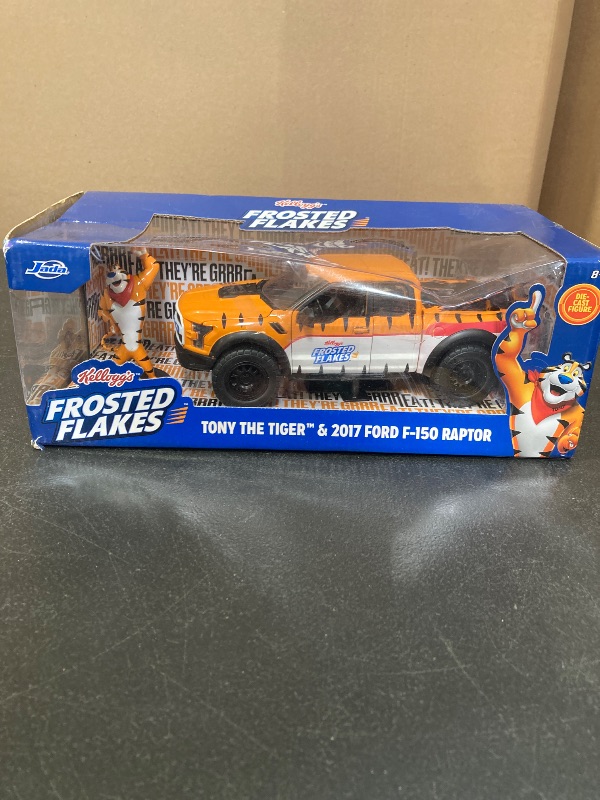 Photo 1 of Jada 2017 Ford F150 Raptor Truck with Kellogg's Frosted Flakes Tony The Tiger Die-Cast Carwith Figure, 1:24 Collectible, Opening Doors, Rubber Tires Ages 8+ (Orange/White)