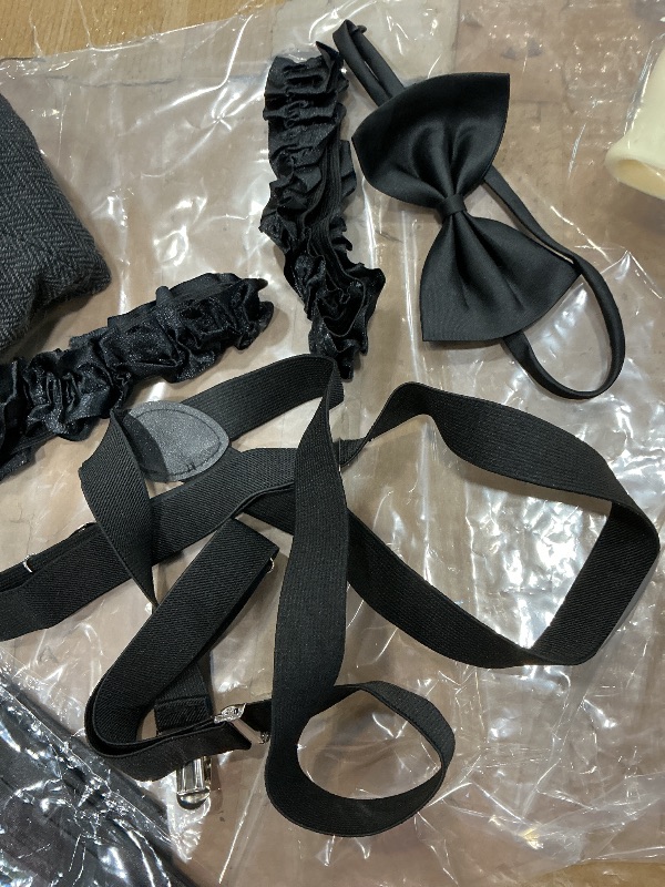 Photo 1 of  a 1920s style accessory costume kit, likely including a newsboy cap, suspenders, a bow tie, and other