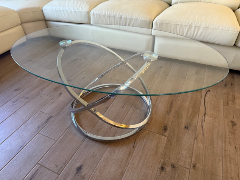 Photo 1 of CONTEMPORARY OVAL CLEAR GLASS COFFEE TABLE W CHROME-TONE METAL RINGS BASE 49" x 28"  H19"