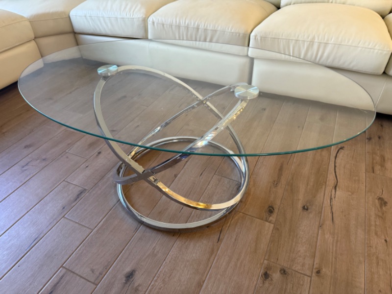 Photo 1 of CONTEMPORARY OVAL CLEAR GLASS COFFEE TABLE W CHROME-TONE METAL RINGS BASE 49" x 28"  H19"