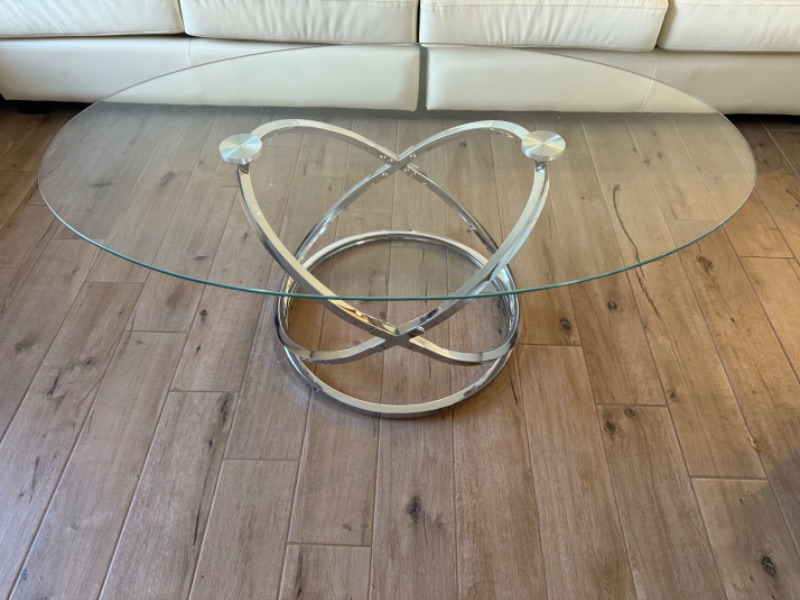 Photo 1 of CONTEMPORARY OVAL CLEAR GLASS COFFEE TABLE W CHROME-TONE METAL RINGS BASE 49" x 28"  H19"