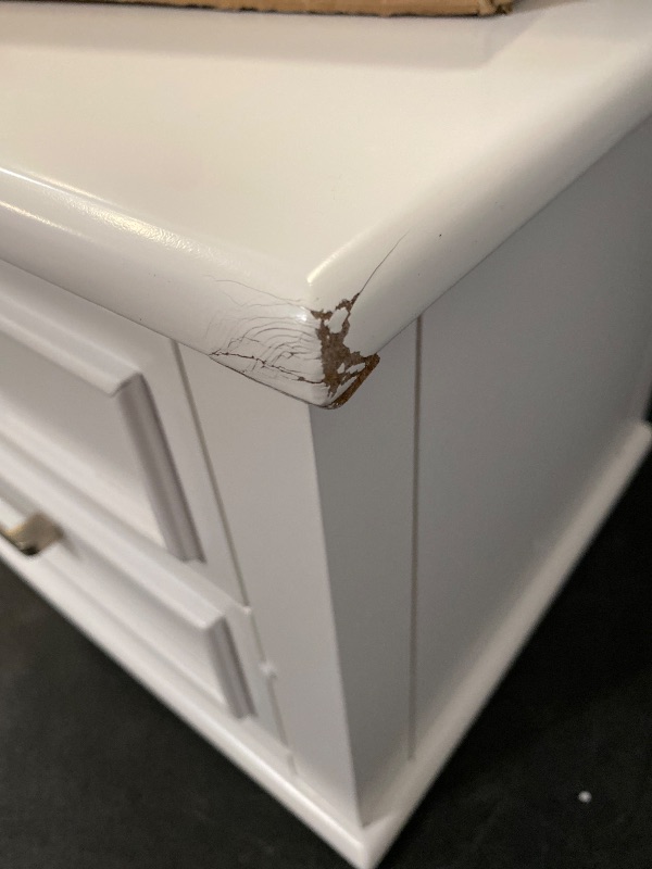Photo 1 of The nightstand balances classic raised molding, delicate tapered feet, and accent satin nickel drawer handles. Both spacious drawers feature dovetail construction with self-closing, ball-bearing drawer glides. Available in a warm white finish