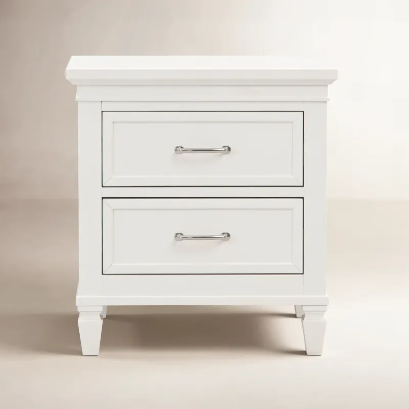 Photo 1 of The nightstand balances classic raised molding, delicate tapered feet, and accent satin nickel drawer handles. Both spacious drawers feature dovetail construction with self-closing, ball-bearing drawer glides. Available in a warm white finish