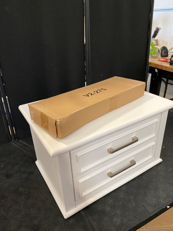 Photo 1 of The nightstand balances classic raised molding, delicate tapered feet, and accent satin nickel drawer handles. Both spacious drawers feature dovetail construction with self-closing, ball-bearing drawer glides. Available in a warm white finish