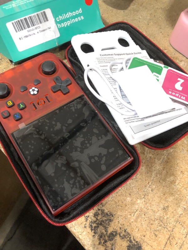 Photo 1 of **CRACKED SCREEN** R36MAX Retro Handheld Game Console - 64GB Preloaded Classic Video Games, Support 30+ Simulators, Linux-Powered Portable Game Emulator Console with 4.0-in HD IPS Screen (Transparent Red)