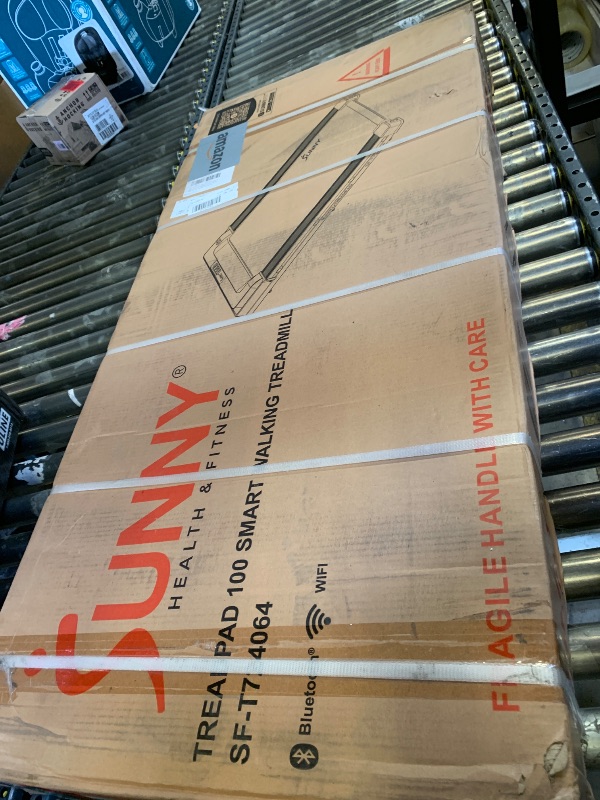 Photo 1 of --FACTORY SEALED-- Sunny Health & Fitness Treadpad 100 Smart Walking Treadmill – Compact, Portable, Under Desk, No Assembly, WiFi & Bluetooth SunnyFit App, Remote Control, LED Display, Shock Absorption - SF-T724064 --FACTORY SEALED--