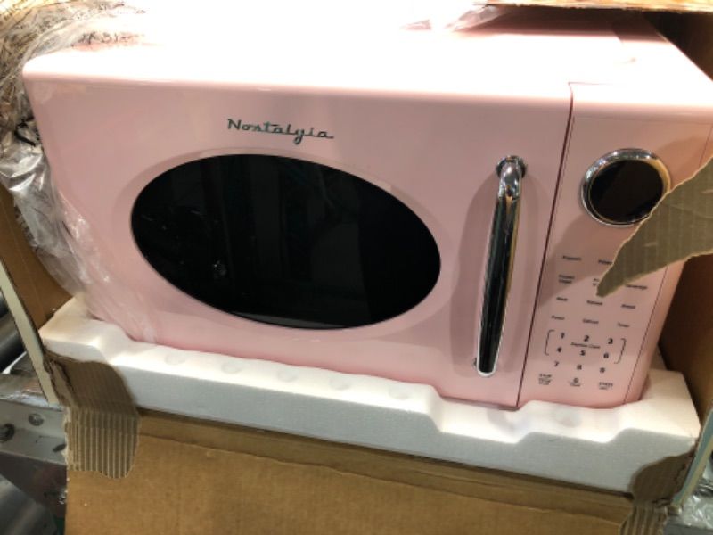 Photo 1 of **BACK IS DENTED*SOLD FOR PARTS* Nostalgia Retro 1000W Microwave Oven 1.1 Cu Ft Capacity – Child Safety Lock, 8 Auto-Cook Settings – Countertop Kitchen Appliance – Pink