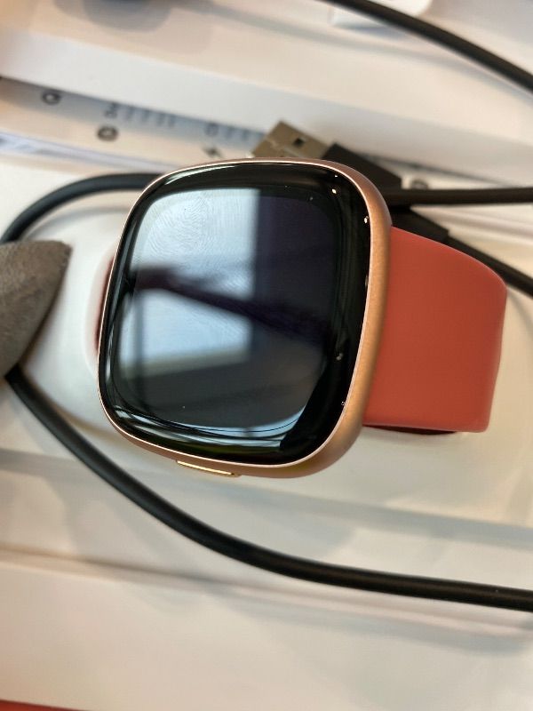 Photo 1 of [NONFUNCTIONAL: DOES NOT HOLD CHARGE] Fitbit Versa 4 Fitness Smartwatch with Daily Readiness, GPS, 24/7 Heart Rate, 40+ Exercise Modes, Sleep Tracking and more, Pink Sand/Copper Rose, One Size (S & L Bands Included)