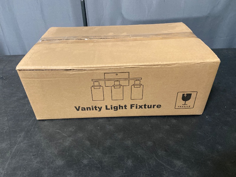 Photo 1 of 3-light matte black bathroom vanity light fixture complete with clear cylindrical glass shades and mounting hardware