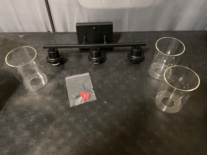 Photo 1 of 3-light matte black bathroom vanity light fixture complete with clear cylindrical glass shades and mounting hardware