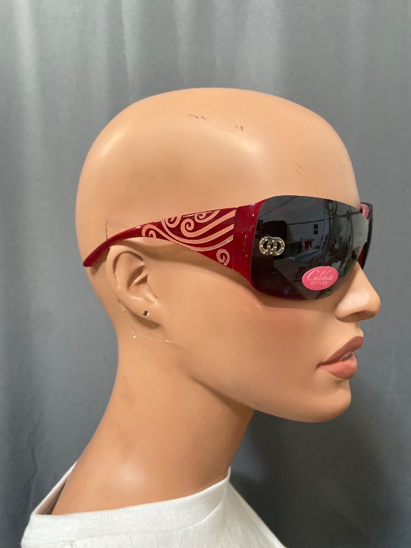 Photo 1 of Celebrity Styles sunglasses feature a rimless, wrap-around design with a single dark shield lens.