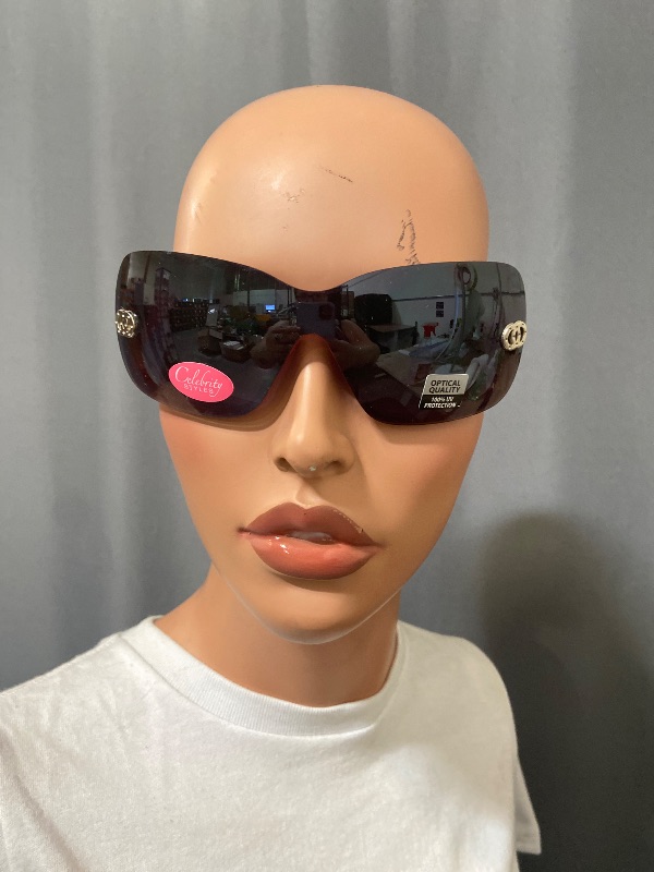 Photo 1 of Celebrity Styles sunglasses feature a rimless, wrap-around design with a single dark shield lens.