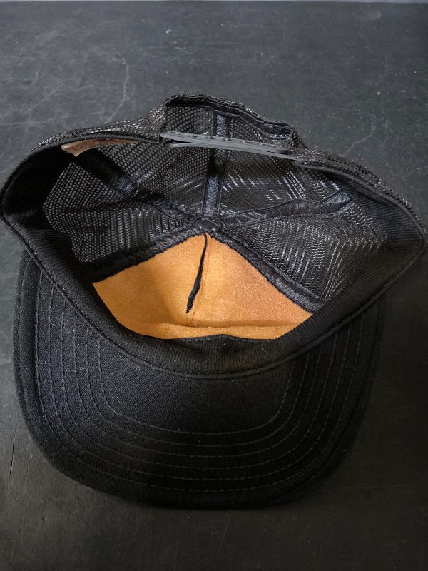 Photo 1 of vintage black trucker hat features a white embroidered "INSTRUCTOR" patch with an aviation-inspired logo.