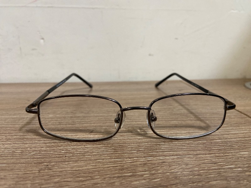 Photo 1 of brown metal eyeglasses are a classic rectangular style designed with comfortable spring hinges, "PL0413 DEAN GUN" inscribed on the temple +2.00 lens power.