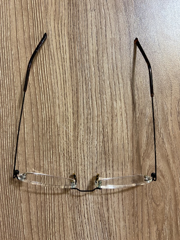 View 2 of +1.25 rimless reading glasses feature a minimalist, frameless rectangular design with sleek black metal temple arms and screw-mount connections.