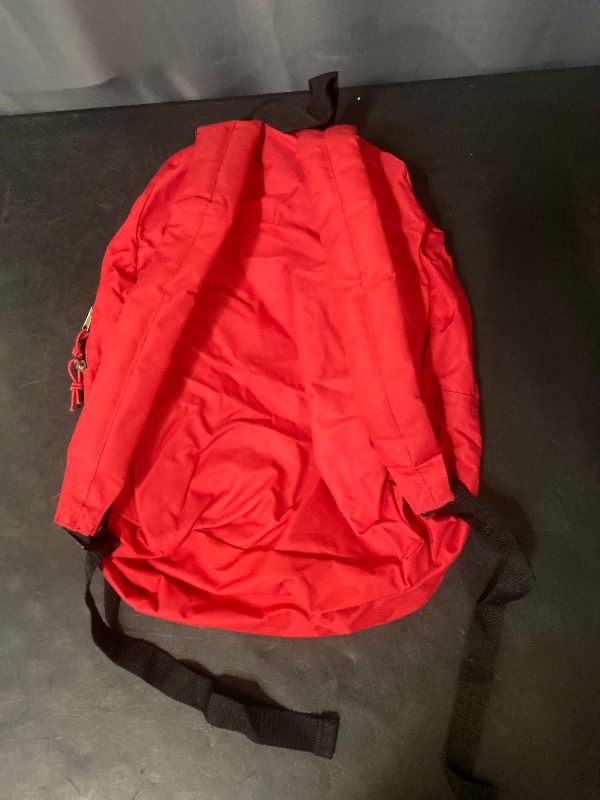Photo 1 of 17inch red classic backpack features a front zippered pocket and an Adventure Trails brand patch on the upper body.