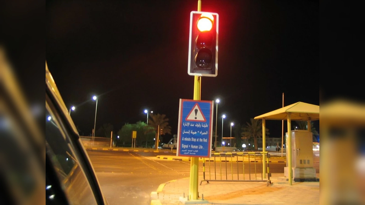 Red traffic signal on a Kuwait road representing reduced traffic violations