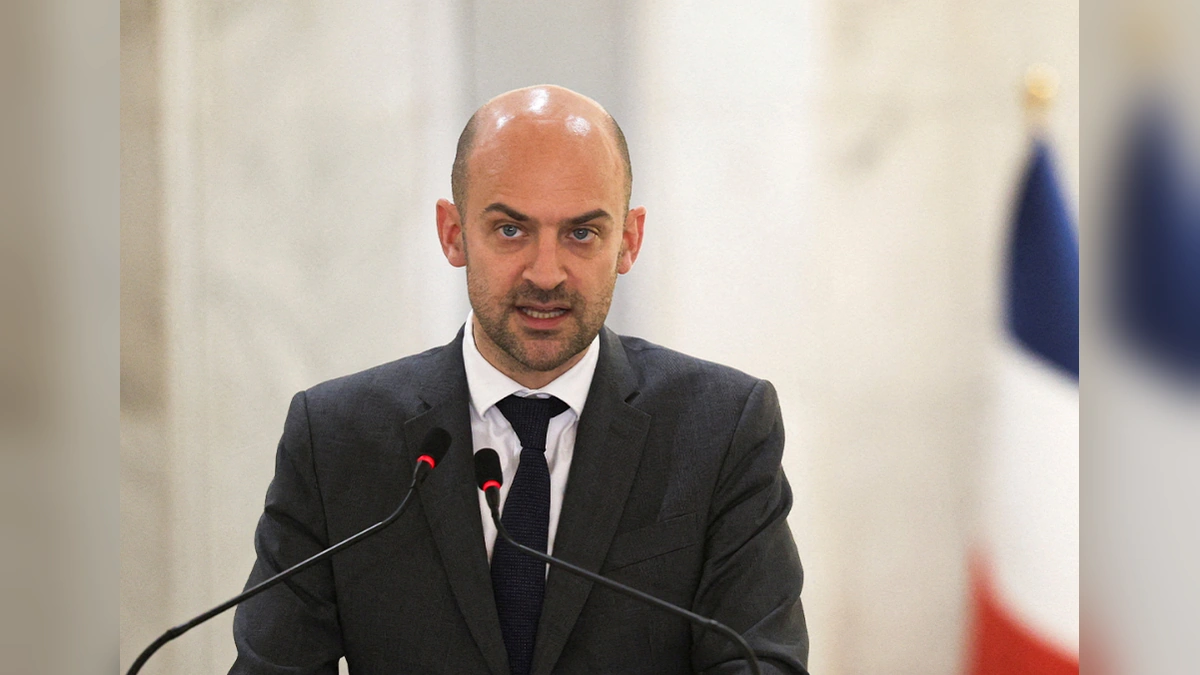 French foreign minister speaking at a podium during a diplomatic briefing