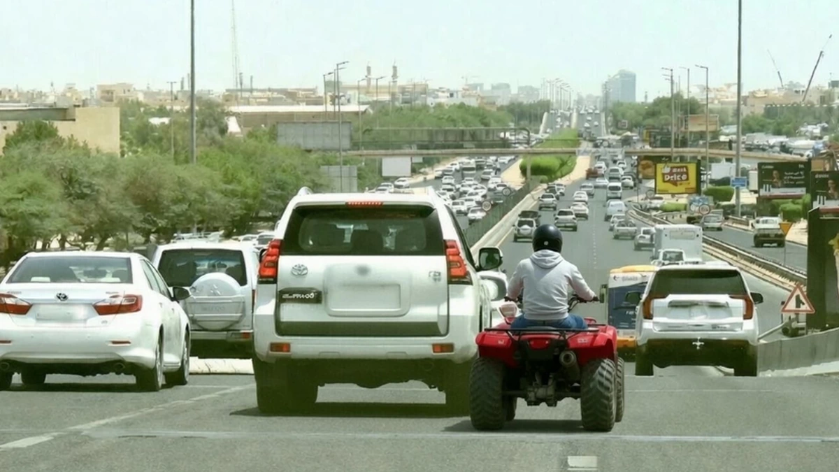 Traffic on a public road in Kuwait with vehicle safety warning